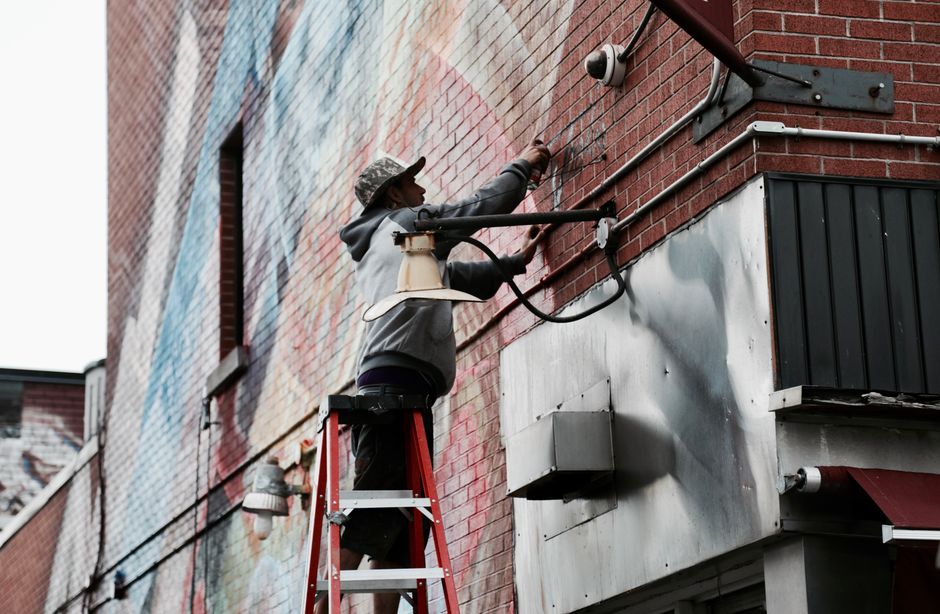 Contractor safely working on a ladder installing house siding
